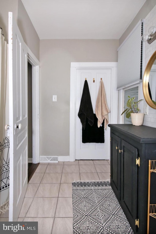 entryway featuring light tile patterned flooring, visible vents, and baseboards