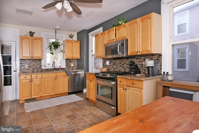 kitchen featuring ceiling fan, appliances with stainless steel finishes, visible vents, and tasteful backsplash