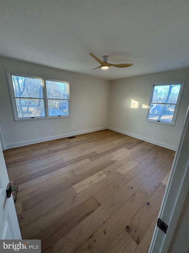 spare room featuring visible vents, a wealth of natural light, and light wood-style floors