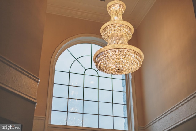 interior details with ornamental molding and a notable chandelier