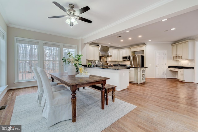 dining area featuring ornamental molding, recessed lighting, and light wood-style flooring