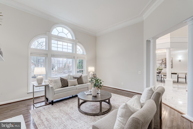 living area with ornamental molding, baseboards, decorative columns, and hardwood / wood-style floors