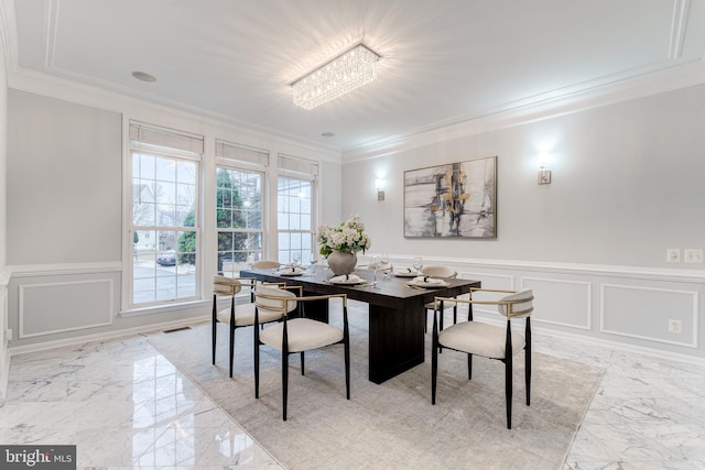 dining space featuring marble finish floor, visible vents, ornamental molding, and a decorative wall