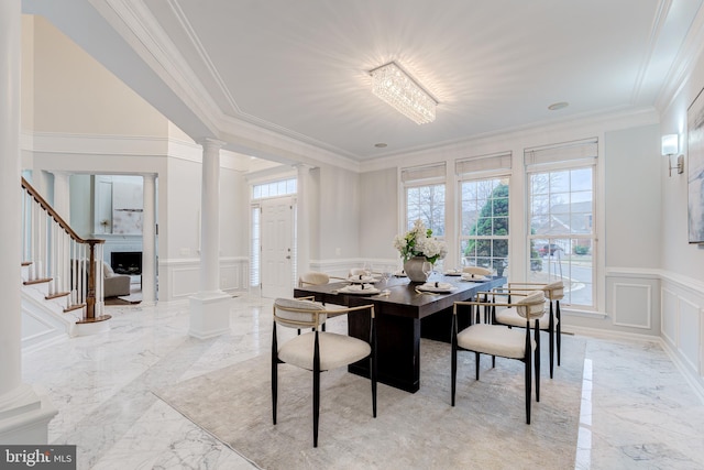 dining area with a decorative wall, stairs, marble finish floor, decorative columns, and crown molding