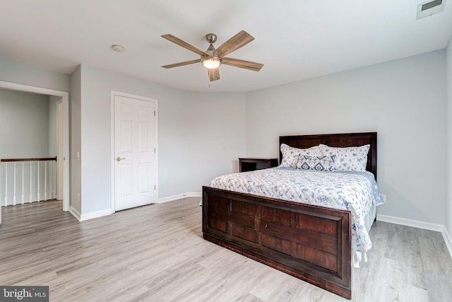 bedroom with light wood-style floors, baseboards, visible vents, and a ceiling fan