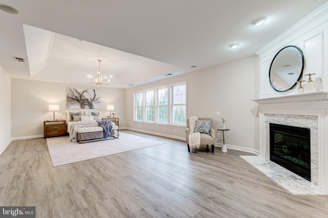 unfurnished bedroom featuring visible vents, a tray ceiling, wood finished floors, and a high end fireplace