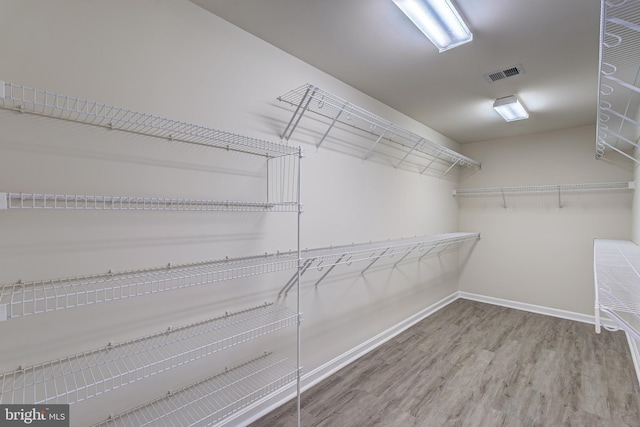 walk in closet featuring visible vents and wood finished floors