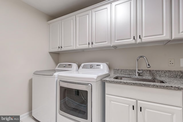 washroom with independent washer and dryer, cabinet space, and a sink