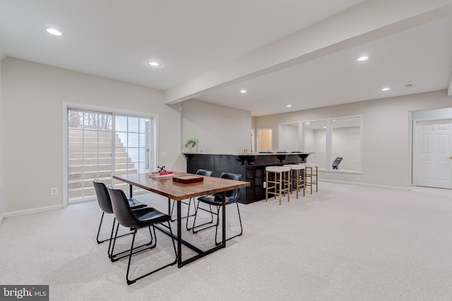 dining area with baseboards, a bar, and recessed lighting