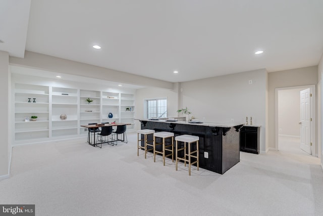 interior space with wet bar, light carpet, baseboards, and recessed lighting