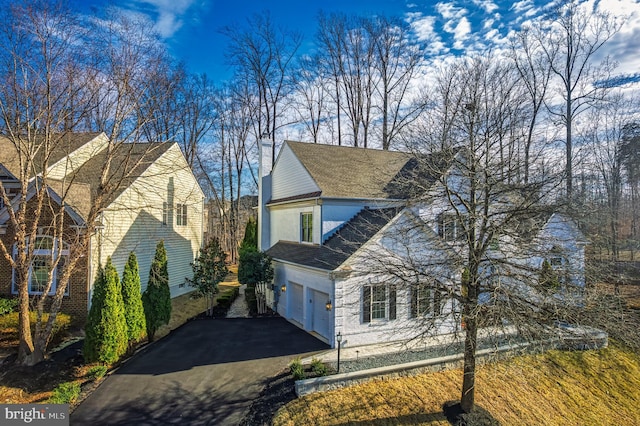 view of front of property with aphalt driveway and a garage