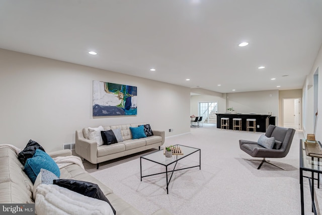 living room featuring recessed lighting, carpet flooring, visible vents, and baseboards