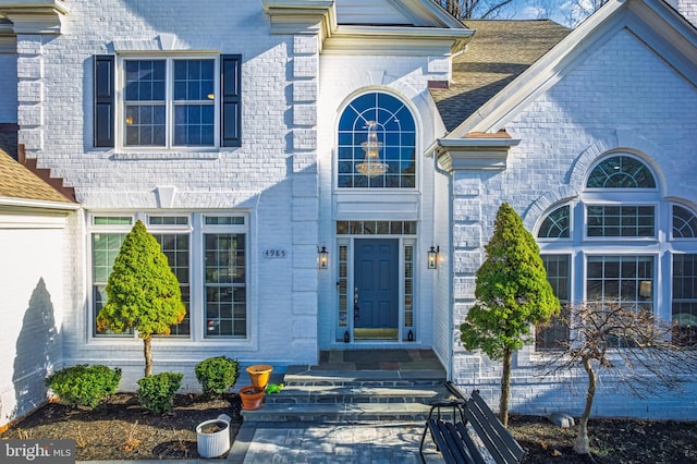 view of exterior entry with brick siding