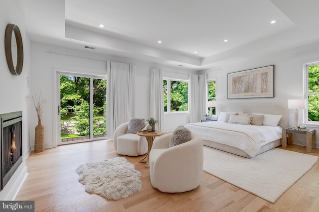5914 Woodley Rd, Mclean, VA 22101 - bedroom featuring a tray ceiling, a lit fireplace, light wood-type flooring, and recessed lighting