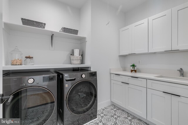 5914 Woodley Rd, Mclean, VA 22101 - washroom featuring washing machine and dryer, cabinet space, light tile patterned floors, and baseboards