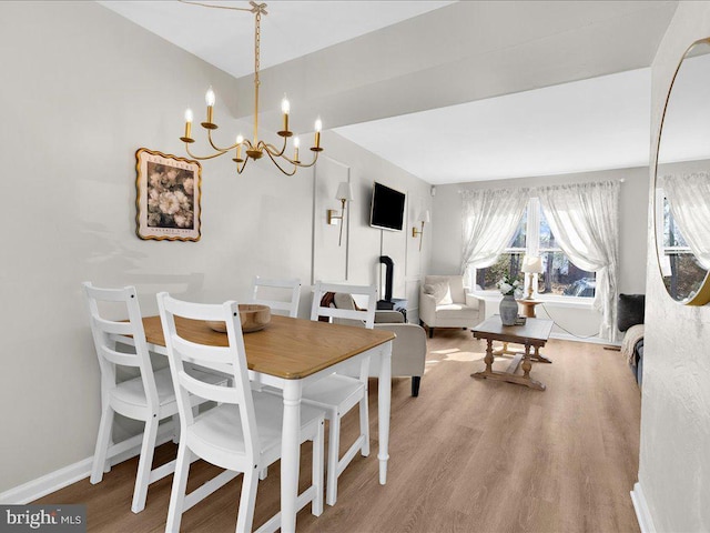 dining room featuring a notable chandelier, baseboards, and wood finished floors