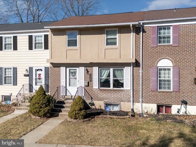 view of property with brick siding and a front yard