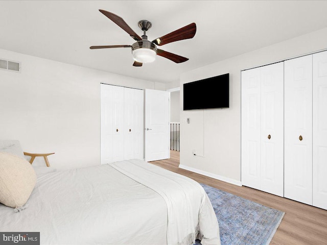 bedroom with a ceiling fan, visible vents, and wood finished floors