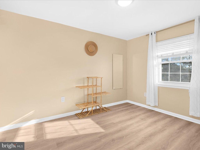 empty room featuring light wood-type flooring and baseboards