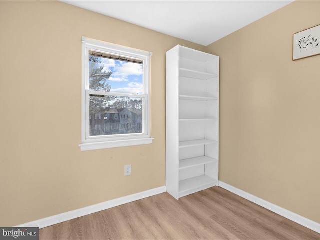 spare room featuring light wood-style flooring and baseboards