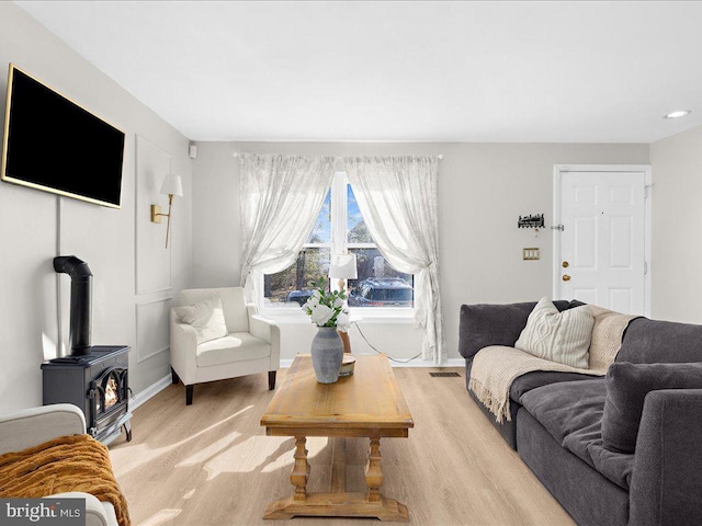 living area featuring a wood stove and baseboards