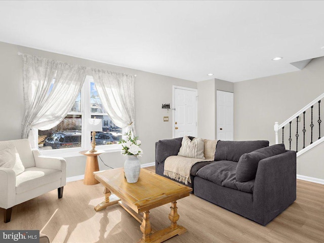 living room with stairs, recessed lighting, light wood-style flooring, and baseboards