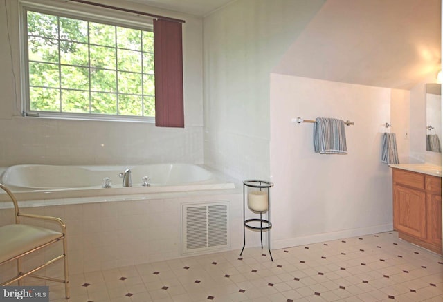 full bathroom with tiled tub, visible vents, vanity, and baseboards