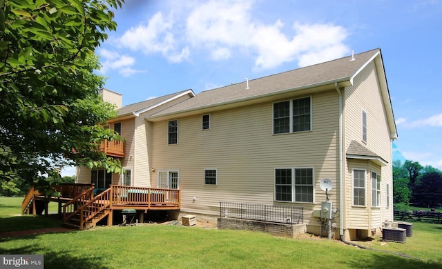 rear view of property featuring a yard, a chimney, and a wooden deck