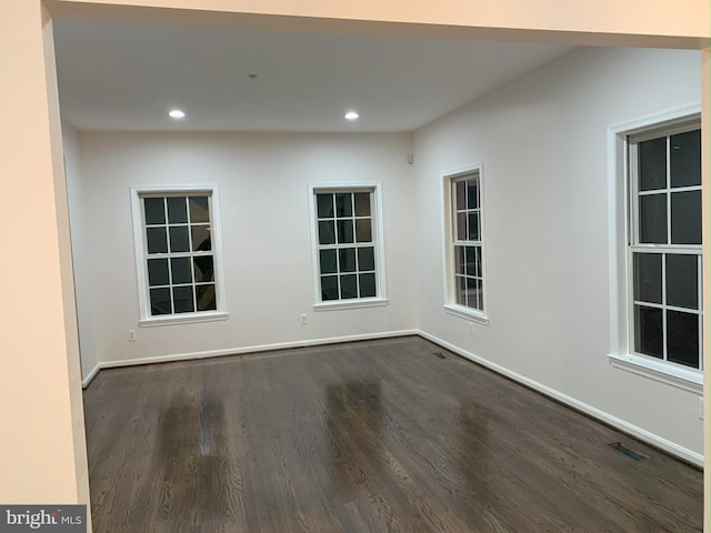 spare room with dark wood-type flooring, recessed lighting, visible vents, and baseboards