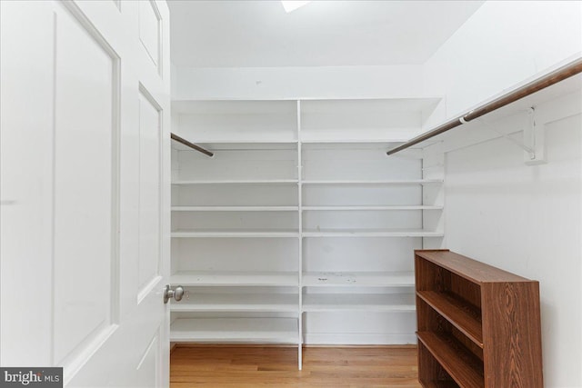 walk in closet with wood finished floors