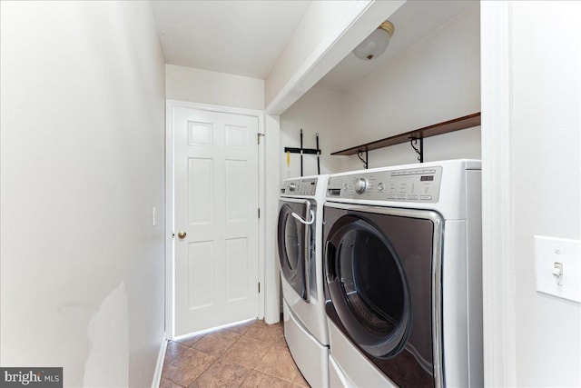 clothes washing area with light tile patterned floors, laundry area, and washing machine and clothes dryer