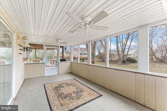 unfurnished sunroom with a ceiling fan