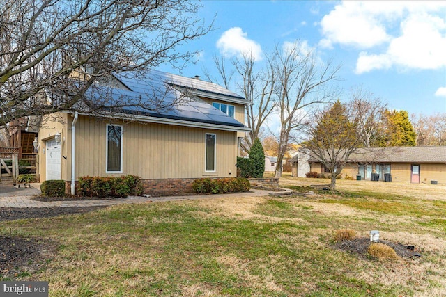 view of home's exterior featuring a yard, an attached garage, and solar panels