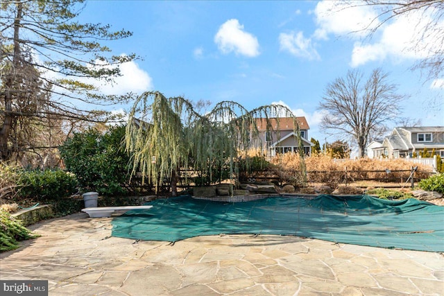 view of swimming pool with a diving board, a patio, and a fenced in pool