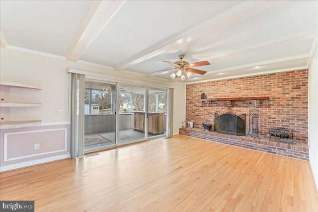 unfurnished living room with a ceiling fan, ornamental molding, wood finished floors, a brick fireplace, and beam ceiling