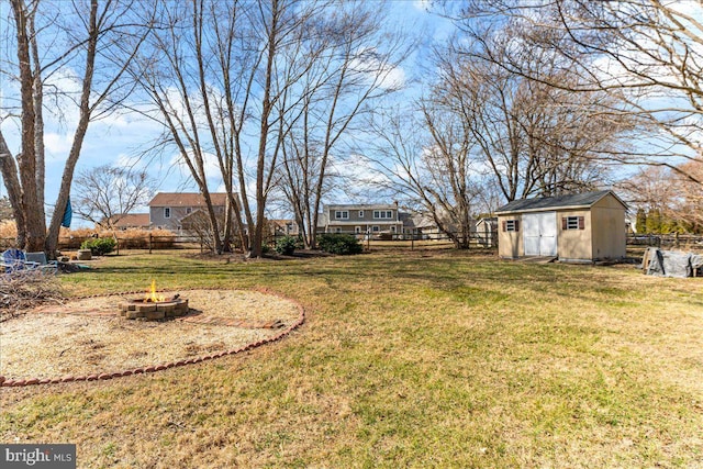 view of yard with a fire pit, a storage shed, an outdoor structure, and fence