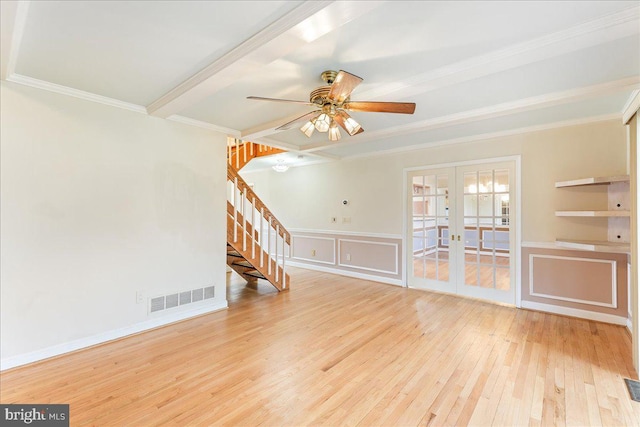 unfurnished living room with french doors, crown molding, visible vents, stairway, and wood finished floors