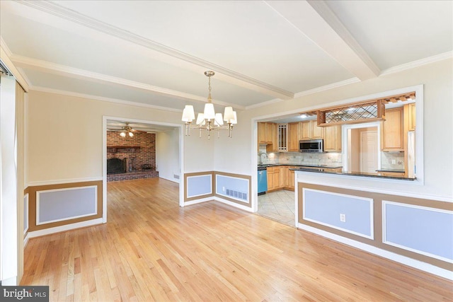 kitchen with a fireplace, tasteful backsplash, stainless steel microwave, visible vents, and beamed ceiling