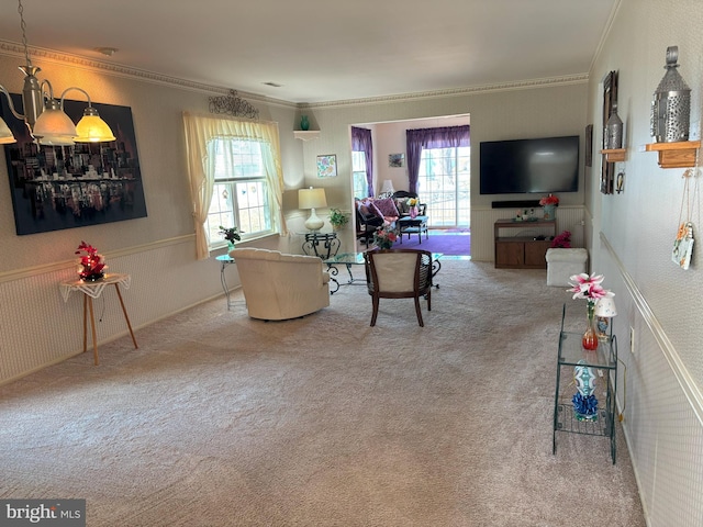 carpeted living area with ornamental molding and wainscoting