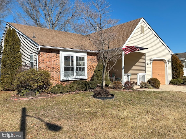 view of front of home with a garage, driveway, brick siding, roof with shingles, and a front yard