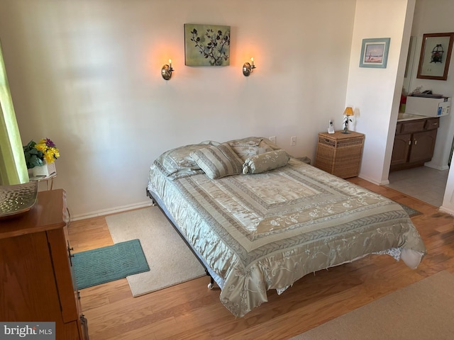 bedroom featuring light wood-style flooring and baseboards