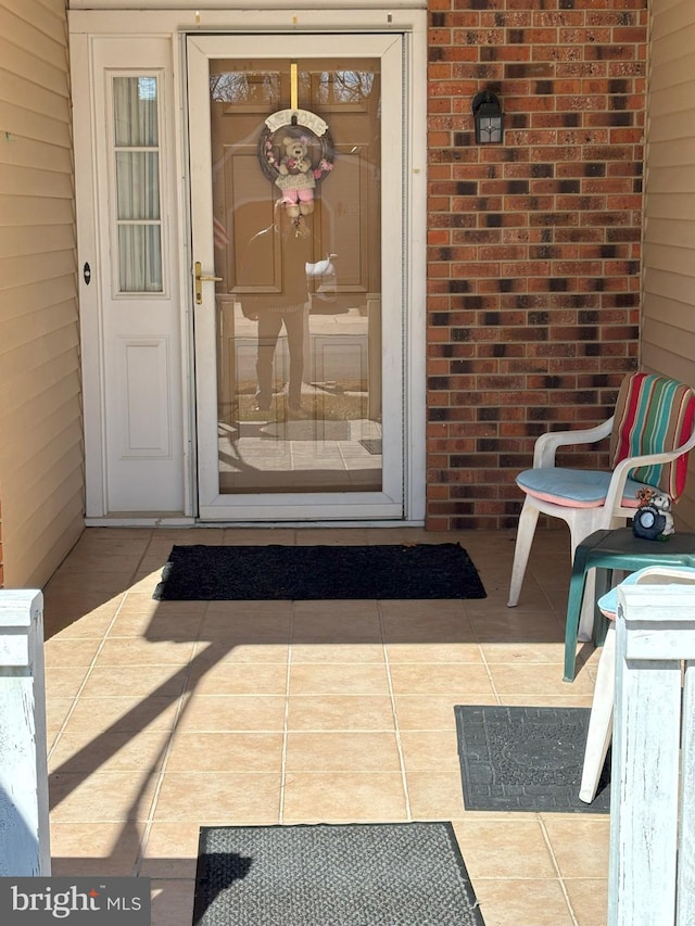 view of exterior entry with brick siding