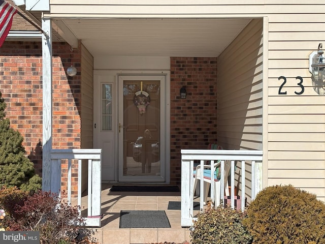 doorway to property with brick siding