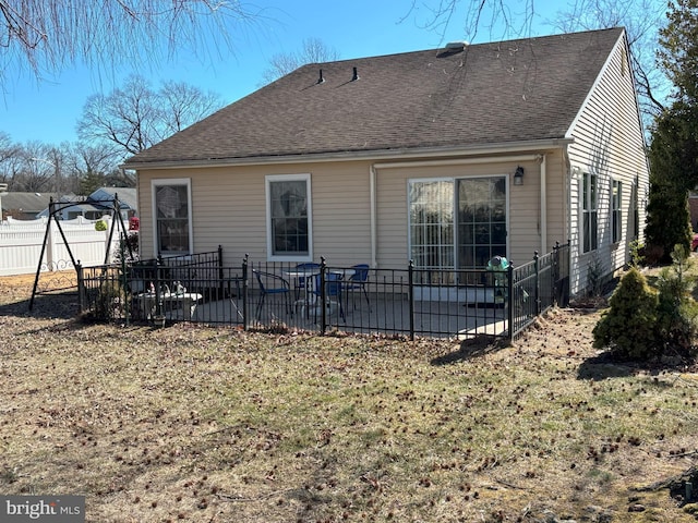 back of house featuring a patio area, roof with shingles, a lawn, and fence