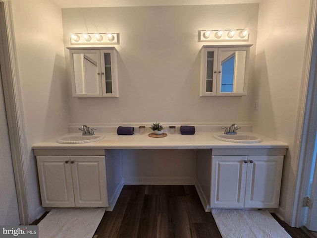 full bath featuring wood finished floors, a sink, and double vanity