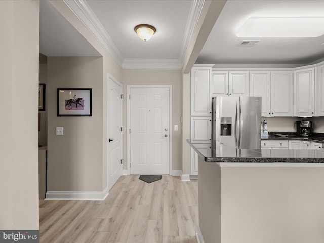 kitchen featuring crown molding, dark countertops, visible vents, white cabinets, and stainless steel fridge