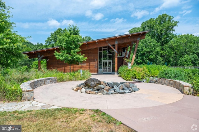 view of patio with french doors, driveway, and a fire pit