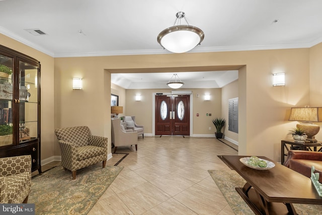 foyer featuring light tile patterned floors, baseboards, visible vents, and ornamental molding