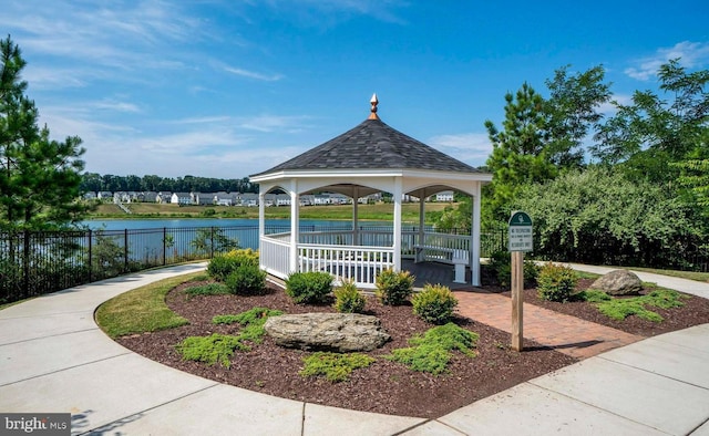 view of home's community with a gazebo, a water view, and fence