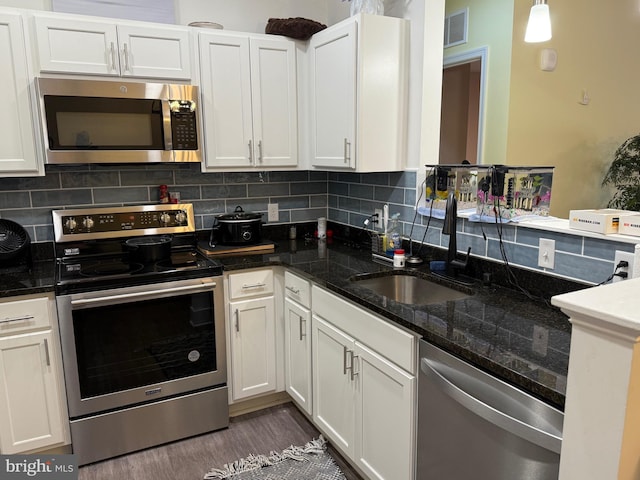 kitchen featuring visible vents, stainless steel appliances, a sink, and white cabinetry